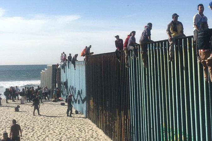 Waves Of Caravan Migrants Arrive In Tijuana, Begin Climbing San Diego ...