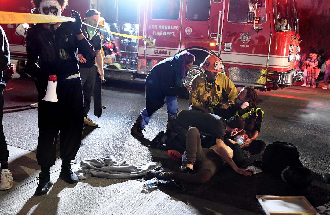 A protester who was hit by a car is attended to as paramedics arrive on Sunset Boulevard. (Wally Skalij/Los Angeles Times)