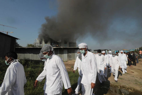 Employees evacuating the burning building, via AP